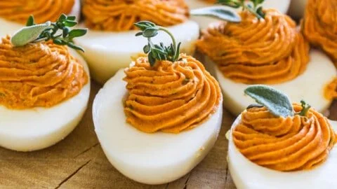 Plate of creamy and smoky deviled eggs garnished with chives