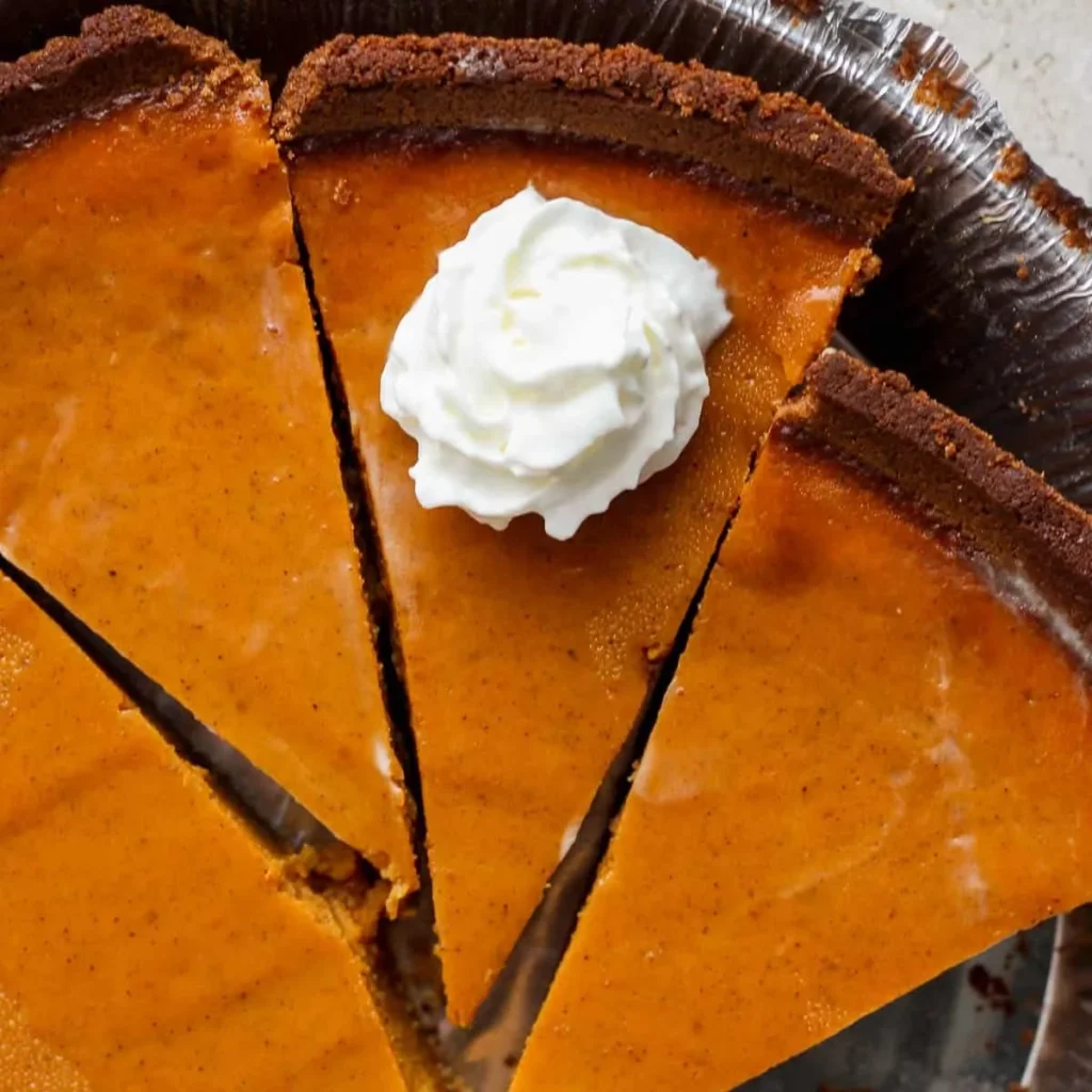Delicious easy pumpkin pie with whipped cream topping on a festive table