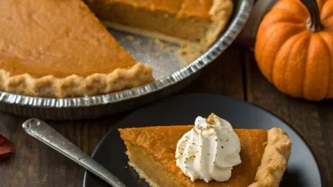 Delicious easy Thanksgiving pumpkin pie ready to serve with whipped cream.