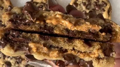 Peanut butter stuffed chocolate chip cookies on a plate.
